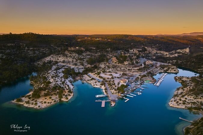 Vue aérienne du Lac d’Esparron-de-Verdon au coucher du soleil avec pontons, embarcations et reliefs boisés environnants